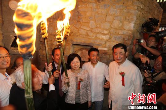 19日午间，在“世界瓷都”江西省景德镇，知名历史学家阎崇年等手持熊熊燃烧象征“薪火相传”的火把，为复建的清代传统窑炉——狮子窑首次复烧点火。 钟新 摄